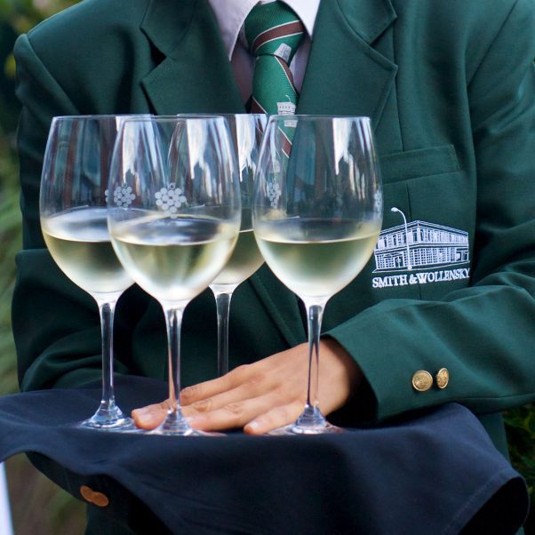 S&W waiter is holding a tray with four glasses of white wine