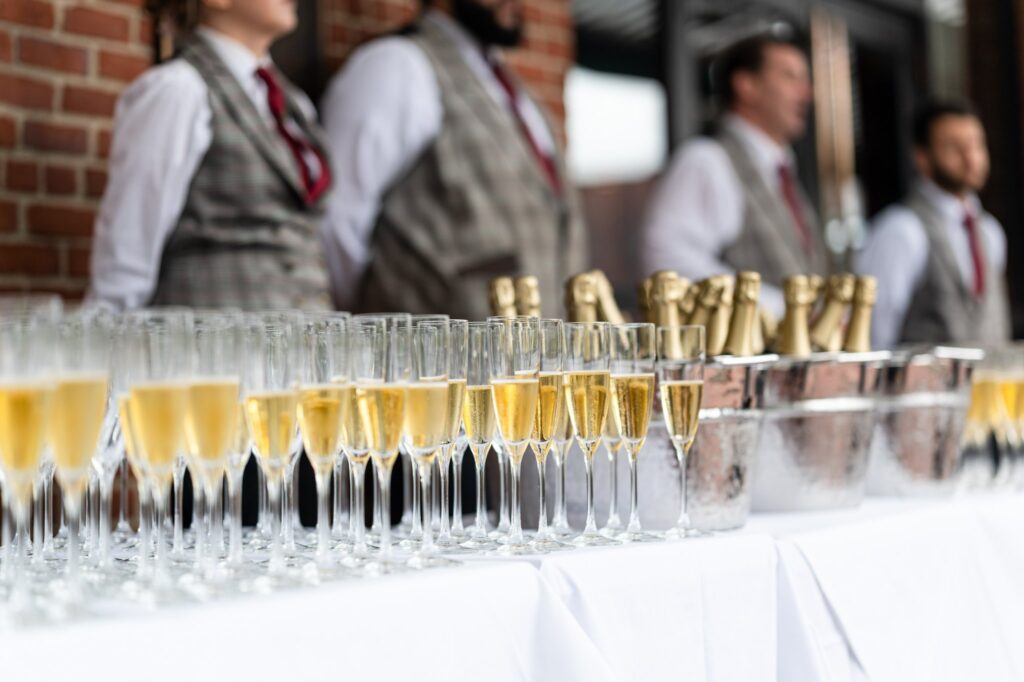 A table with rows of filled Champagne glasses
