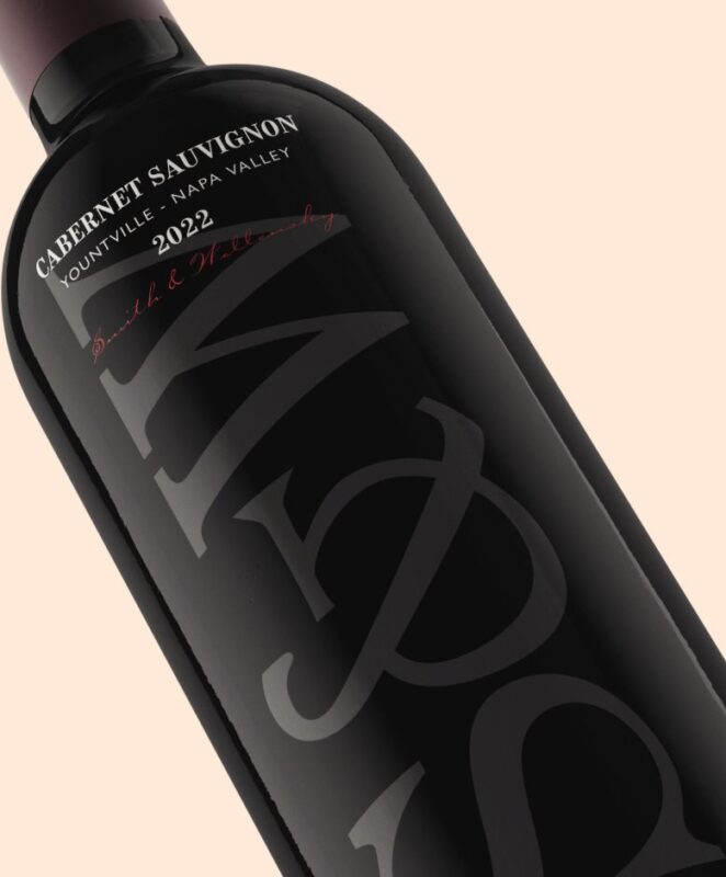 A close-up of a bottle of Cabernet Sauvignon wine, vintage 2022, from Yountville, Napa Valley. The label features large stylized text and elegant script on a dark bottle against a light background.