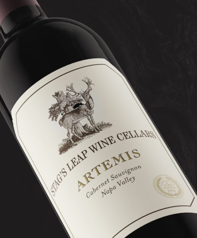 A close-up of a wine bottle labeled “Stag’s Leap Wine Cellars ARTEMIS Cabernet Sauvignon Napa Valley” featuring an illustration of a stag and gold foil details on a cream label.
